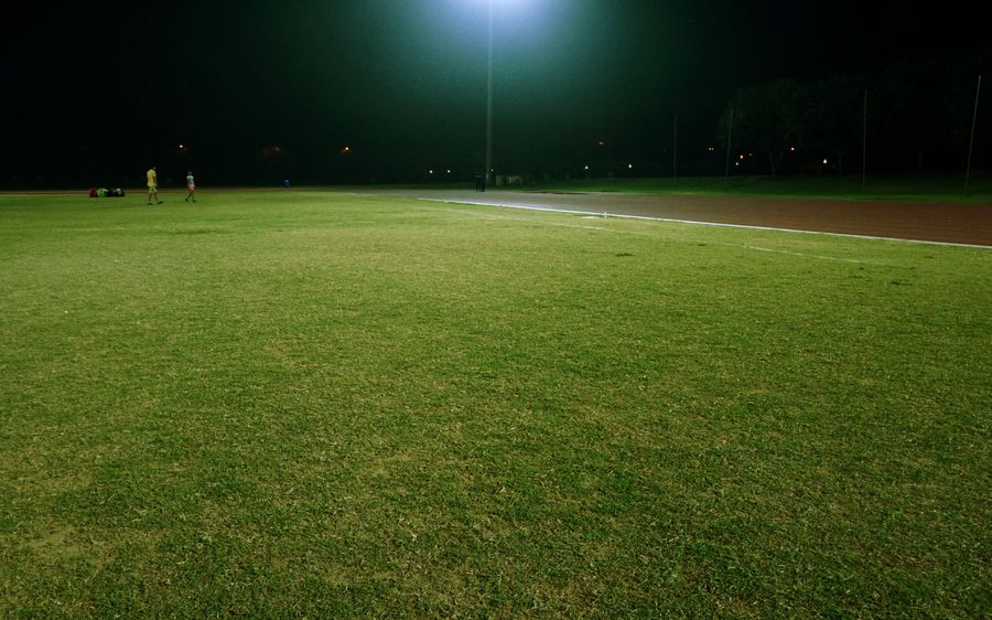 Footballers celebrating on a floodlit pitch